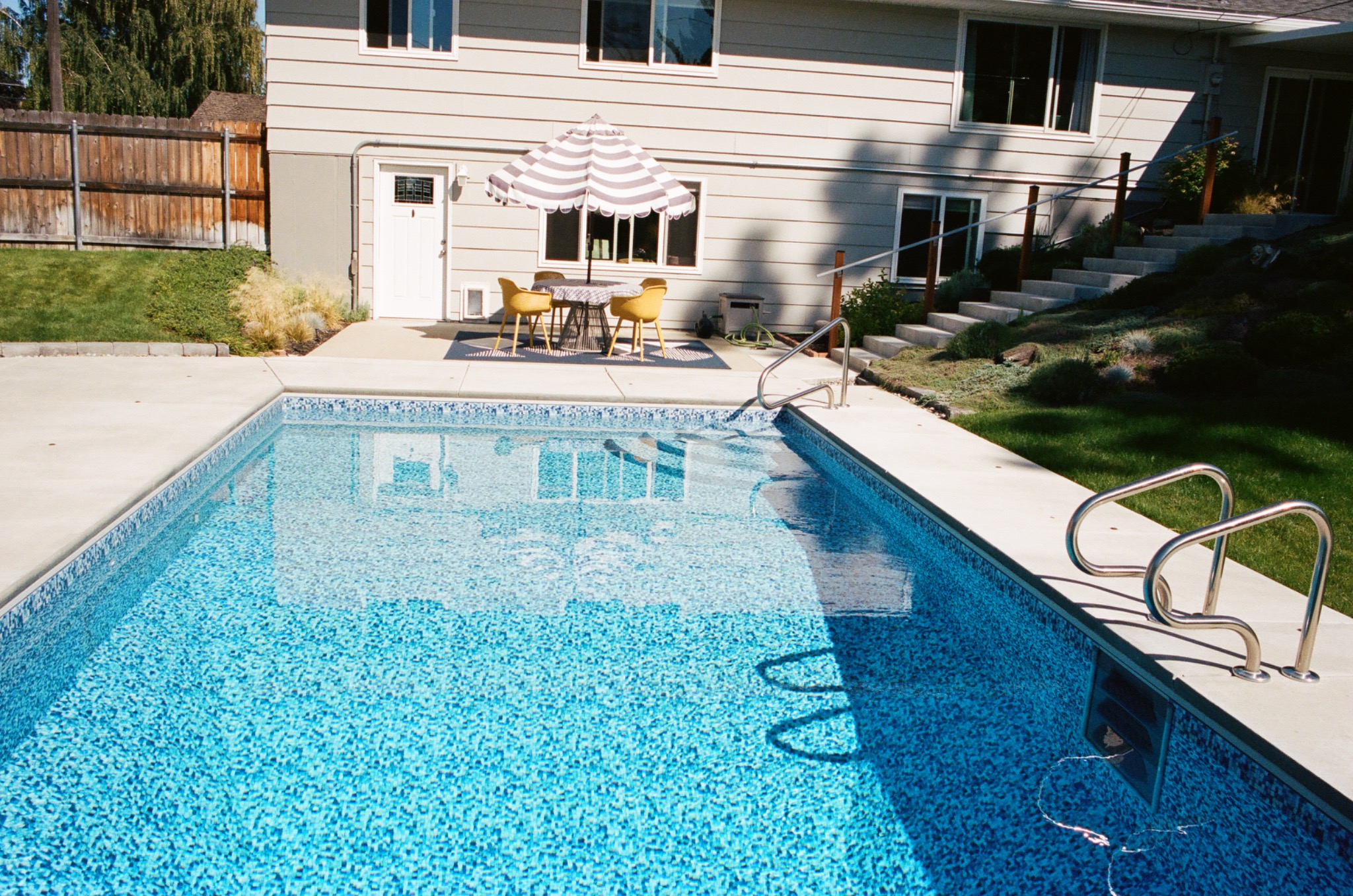 A backyard swimming pool in bright afternoon light