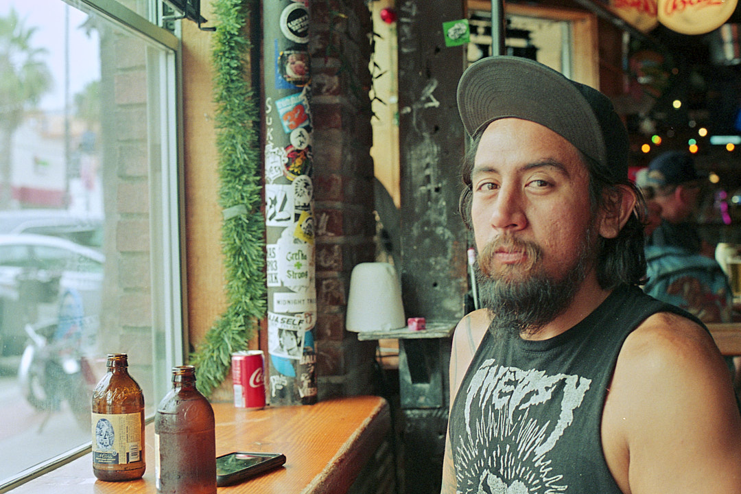 Portrait of a man seated beside a bar window