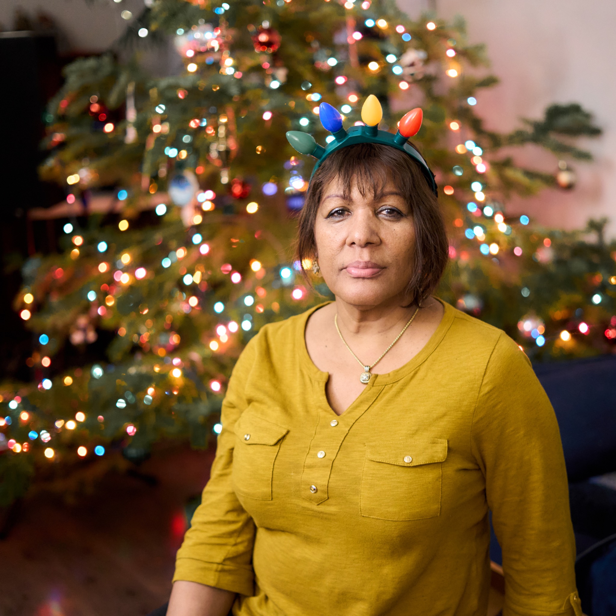 A quiet portrait in front of a Christmas tree with a colorful light crown
